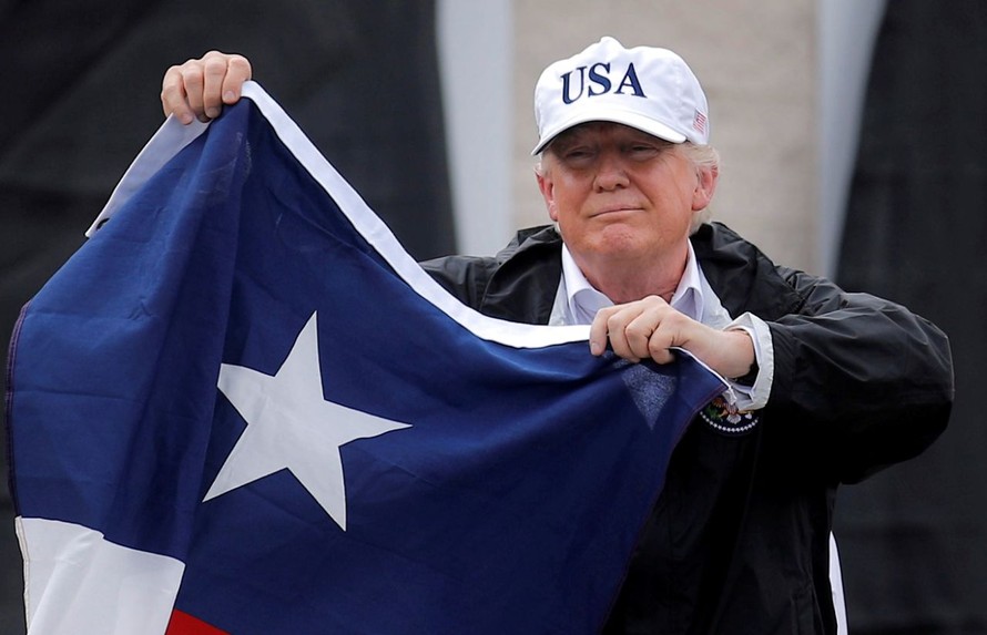 Tổng thống Trump vẫy lá cờ của bang Texas khi đến thăm bang này vào ngày 29/8. Ảnh: Reuters