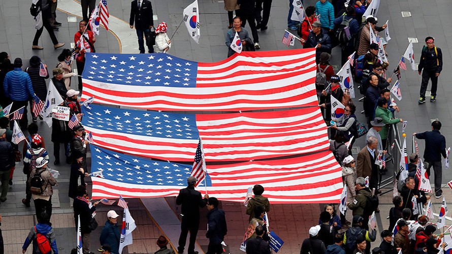 Những người ủng hộ Tổng thống Mỹ Donald Trump cầm cờ Mỹ khi đang chờ đoàn xe của ông Trump chạy qua ở khu vực trung tâm Seoul (Hàn Quốc). Ảnh: Kim Kyung Hoon