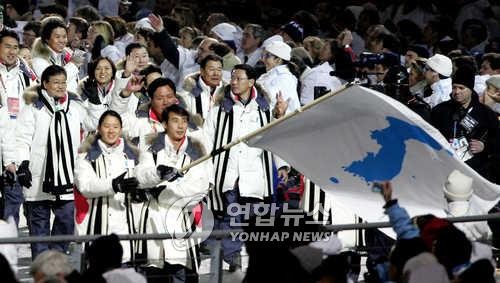 Lee Bo-ra (trái) và Han Jong-in cầm cờ trong lễ khai mạc Olympic Mùa đông 2006 ở Turin (Ý). Ảnh: Yonhap