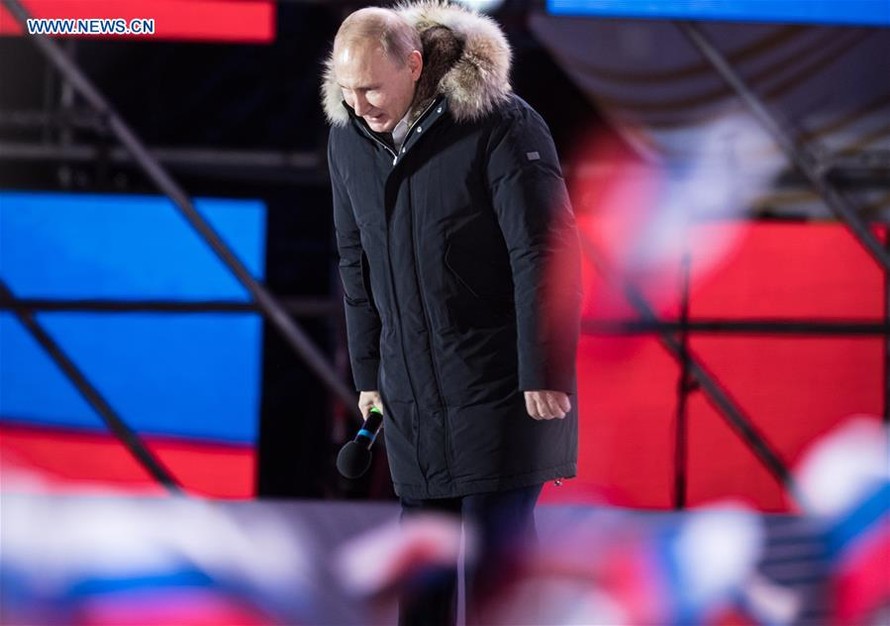 Tổng thống Nga Vladimir Putin cúi chào người dân Nga tại Moscow trong một cuộc mít tinh diễn ra tối 18/3. Ảnh: Tân Hoa Xã