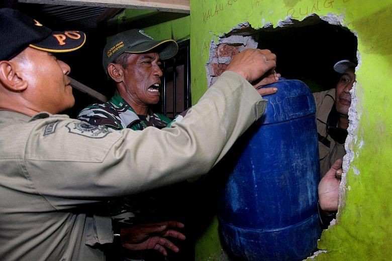 Cảnh sát thu giữ rượu trái phép tại Tây Java hôm 8/4. Ảnh: AP