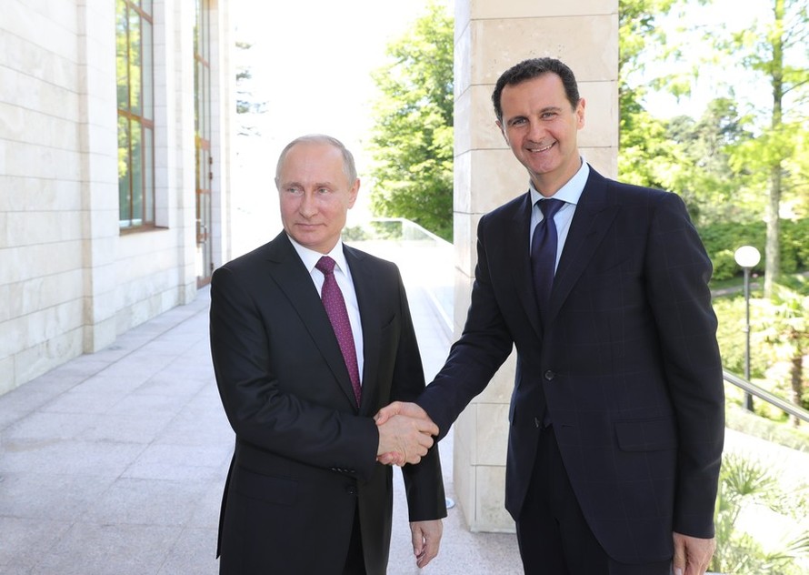 Tổng thống Nga Putin bắt tay Tổng thống Syria Assad. Ảnh: Sputnik