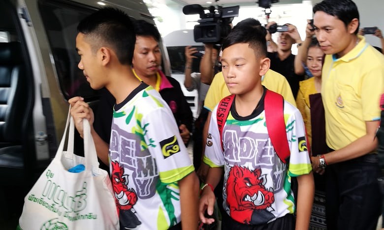 Các cầu thủ nhí Thái Lan mặc đồng phục khi xuất viện. Ảnh: EPA