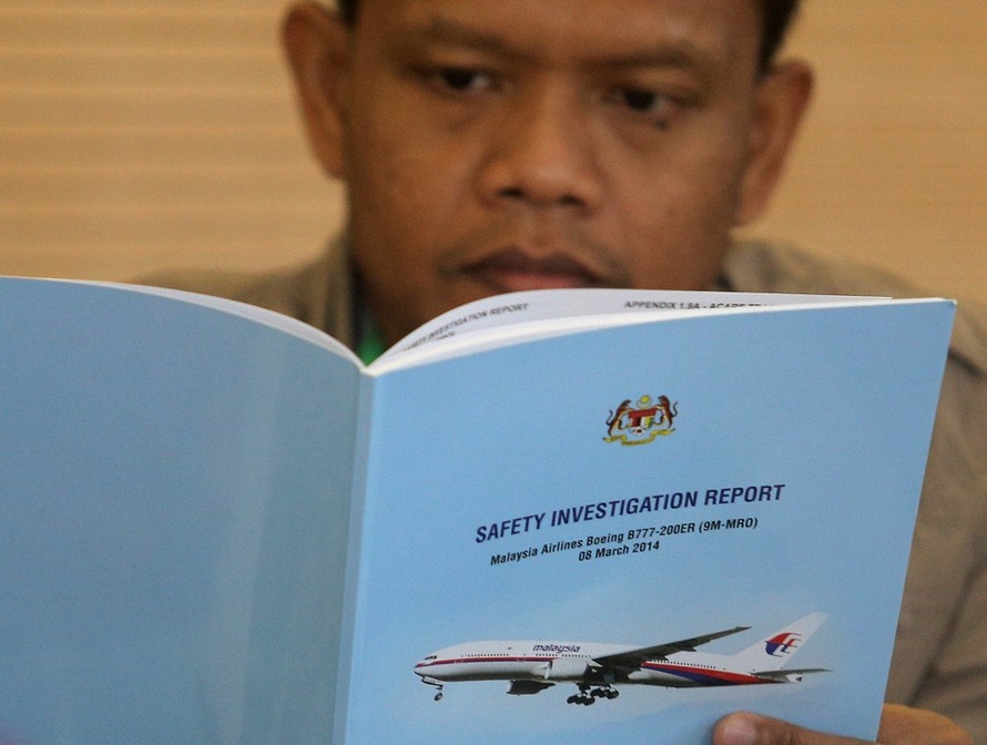 Thân nhân các nạn nhân trên chiếc MH370 đọc báo cáo về vụ tai nạn sáng 30/7. Ảnh: Malay Mail