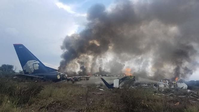 Máy bay bốc cháy sau khi trượt dài trên đường. Ảnh: AFP