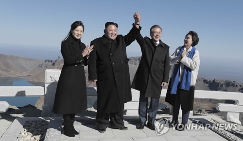 Tổng thống Hàn Quốc và Chủ tịch Triều Tiên nắm tay tươi cười trên đỉnh Paekdu. Ảnh: Yonhap