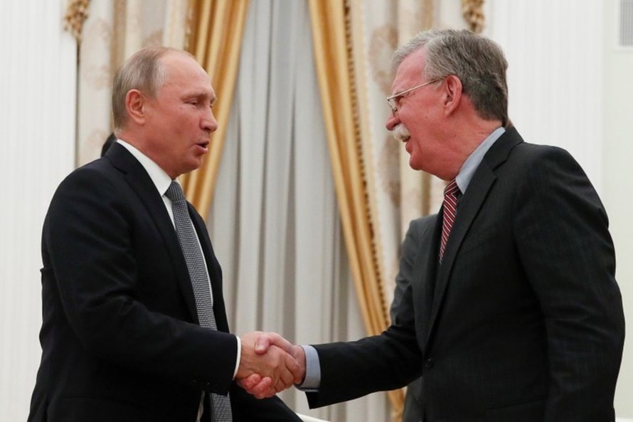 Tổng thống Nga Putin (trái) bắt tay Cố vấn An ninh Mỹ Bolton (phải) trong cuộc gặp ngày 23/10. Ảnh: Reuters