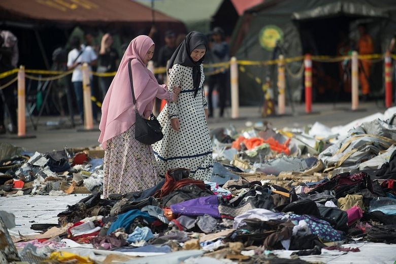 Thân nhân đau đớn tìm tư trang của nạn nhân vụ rơi máy bay Lion Air JT610. Ảnh: AFP