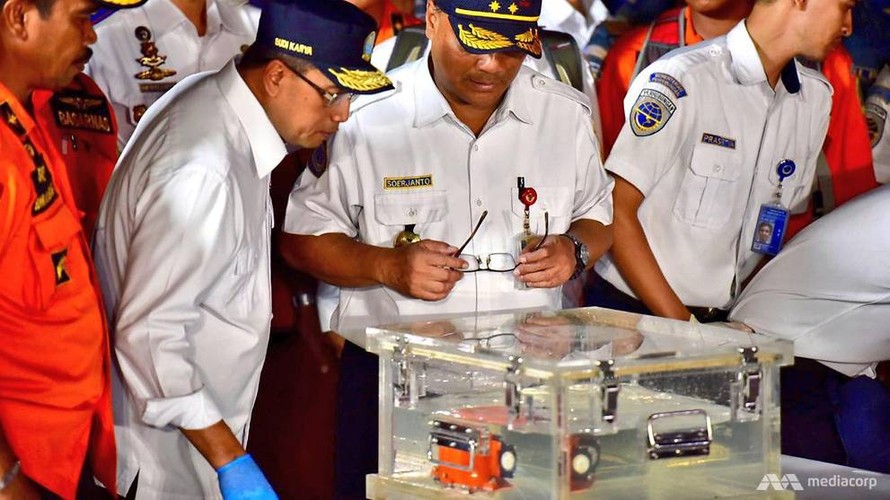 Các quan chức Indonesia xem xét chiếc hộp đen (màu da cam) được đựng trong thùng nước tại cảng Jakarta. Ảnh: CNA