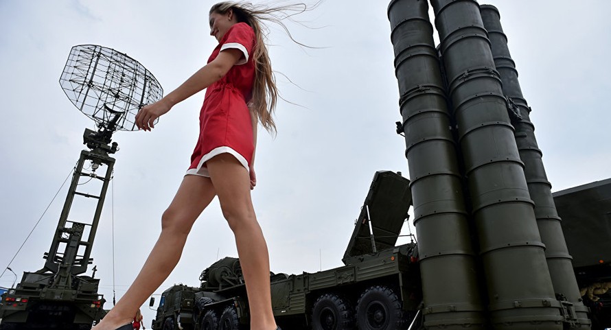 Một cô gái trẻ bước ngang qua hệ thống phòng không S-400 tại triển lãm quân sự. Ảnh: AFP