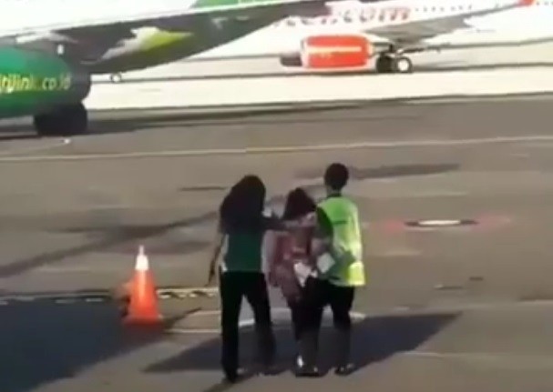 Bà Hana bị nhân viên an ninh giữ lại trong khi chiếc máy bay Citilink đang lăn bánh trên đường băng. Ảnh cắt từ video