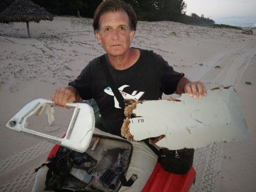 Blaine Gibson cùng các mảnh vỡ máy bay được tìm thấy tại Madagascar. Ảnh: EPA