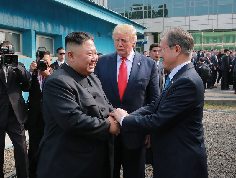 Tổng thống Mỹ Trump và Tổng thống Hàn Quốc Moon tạm biệt Chủ tịch Kim tại DMZ sau cuộc gặp ngày 30/6. Ảnh: AP