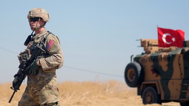 Binh sĩ Mỹ đứng trước xe quân sự của quân đội Thổ Nhĩ Kỳ. Ảnh: Reuters