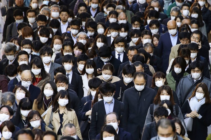 Người dân Tokyo đeo khẩu trang kín mít. Ảnh: Kyodo