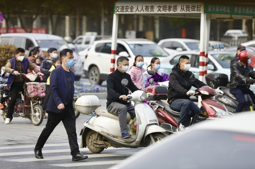 Người dân thị trấn Hiếu Cảm (tỉnh Hồ Bắc) đi lại trên đường hôm 23/3. Ảnh: China Daily