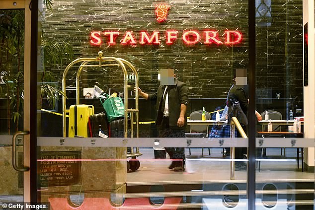 Nhân viên khách sạn Stamford ở Melbourne (bang Victoria) kéo hành lý cho các du khách bị cách ly. Ảnh: Getty
