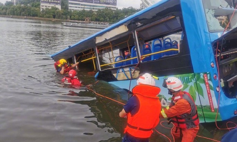 Chiếc xe buýt trống trơn được kéo lên từ dưới hồ. Ảnh: Global Times