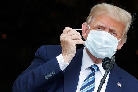 Tổng thống Trump cởi khẩu trang khi phát biểu từ ban công Nhà Trắng ngày 10/10. Trên tay Tổng thống có dán băng y tế. Ảnh: Reuters
