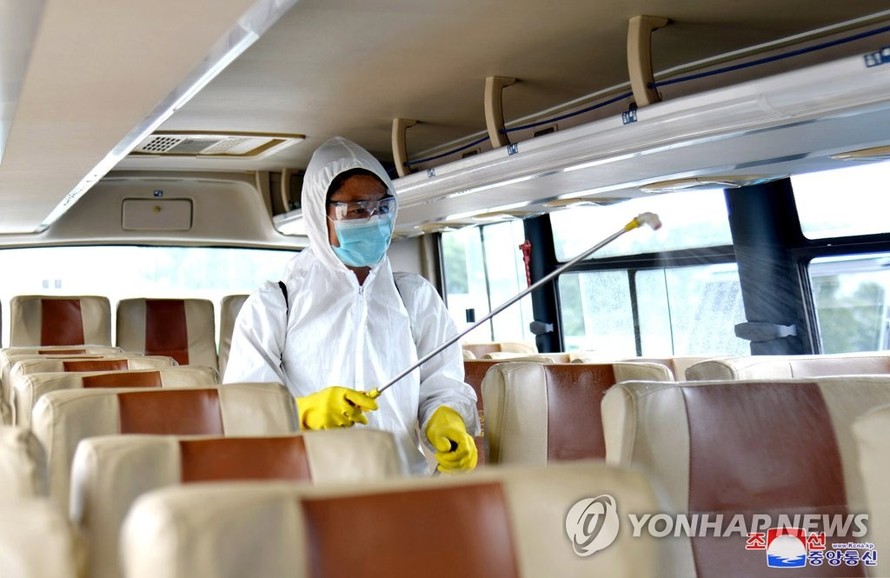 Nhân viên khử trùng xe buýt ở Triều Tiên. Ảnh: Yonhap