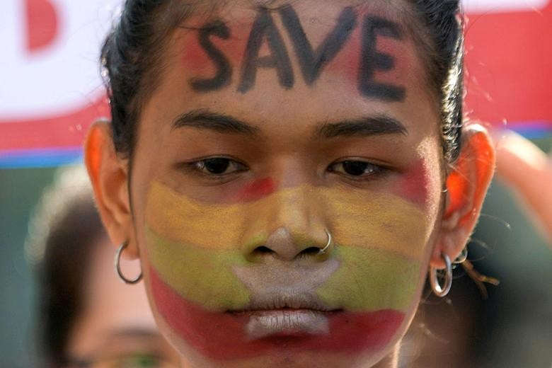 Người biểu tình ở Myanmar viết khẩu hiệu kêu cứu lên mặt. Ảnh: Reuters