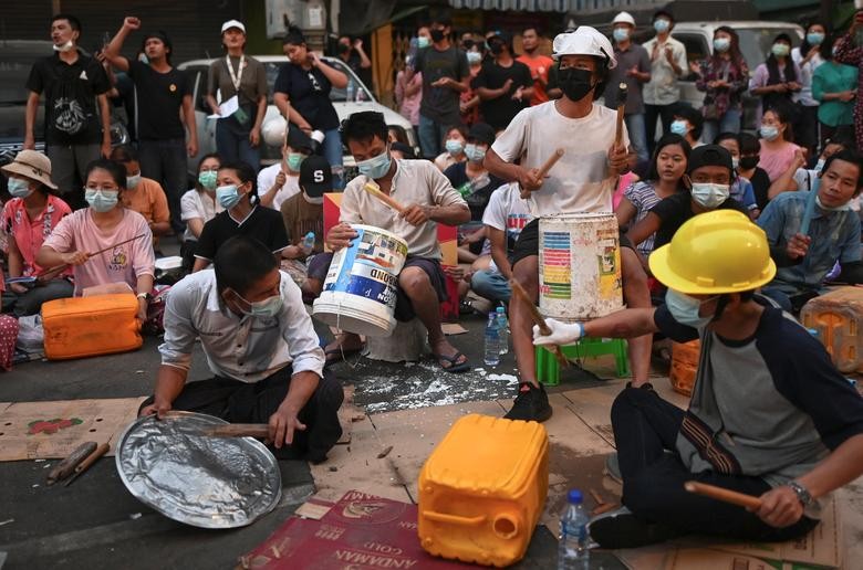 Người biểu tình Myanmar ngồi gõ nắp vung, thùng nhựa trên phố ngày 14/3. Ảnh: Reuters