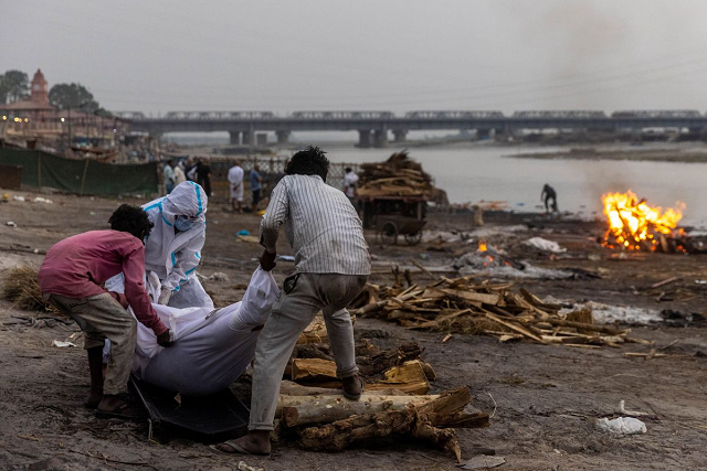 Thi thể bệnh nhân COVID-19 được hỏa táng bên bờ sông ở Ấn Độ. Ảnh: Reuters