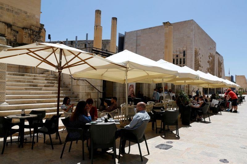 Người dân trò chuyện tại một quán cafe ở Malta hồi đầu tháng Năm. Ảnh: Reuters