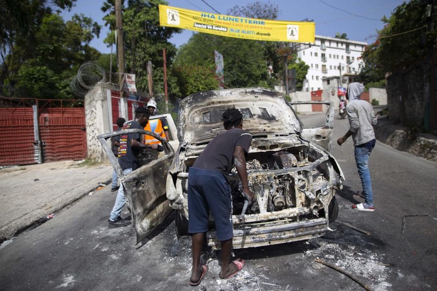 Một chiếc xe bị người biểu tình đốt phá trên đường phố Haiti. Ảnh: AP