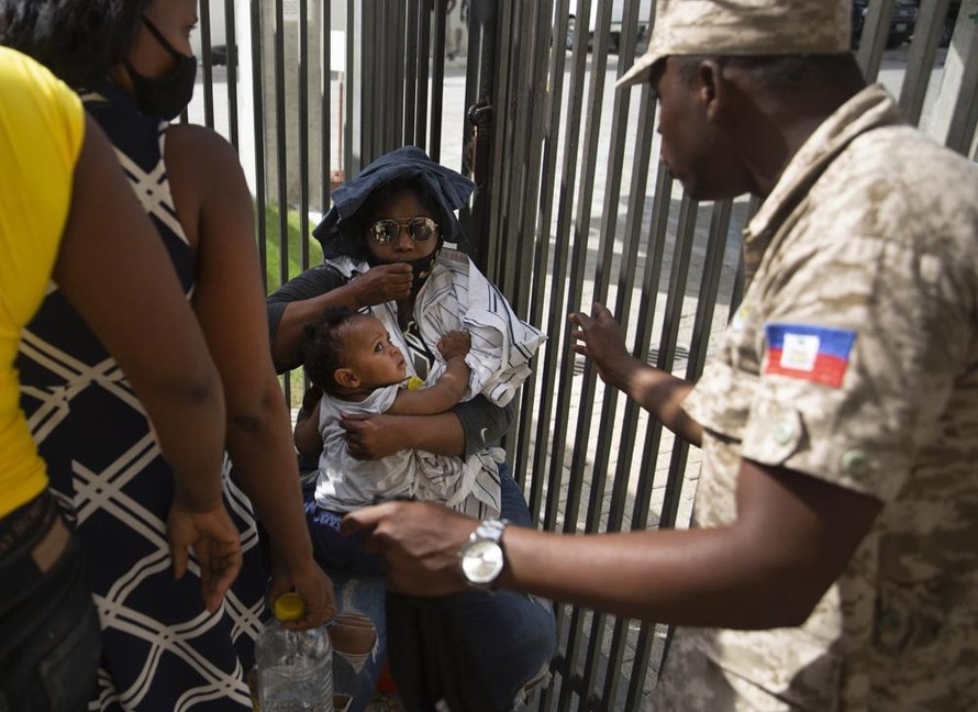 Cảnh sát Haiti yêu cầu người dân tránh xa khu vực Đại sứ quán Mỹ ở thủ đô Port-au-Prince trong bối cảnh nhiều người tụ tập bên ngoài, vẫy hộ chiếu để xin tị nạn ở Mỹ. Ảnh: AP