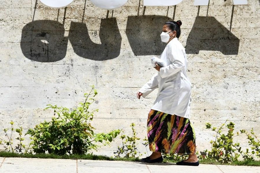 Một phụ nữ đeo khẩu trang đi bộ ở thủ đô Havana (Cuba). Ảnh: Tân Hoa Xã