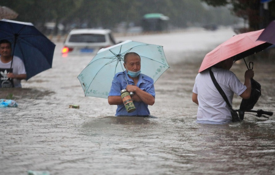 Nước ngập ngang thắt lưng người đi đường ở Trịnh Châu (Hà Nam, Trung Quốc). Ảnh: Reuters