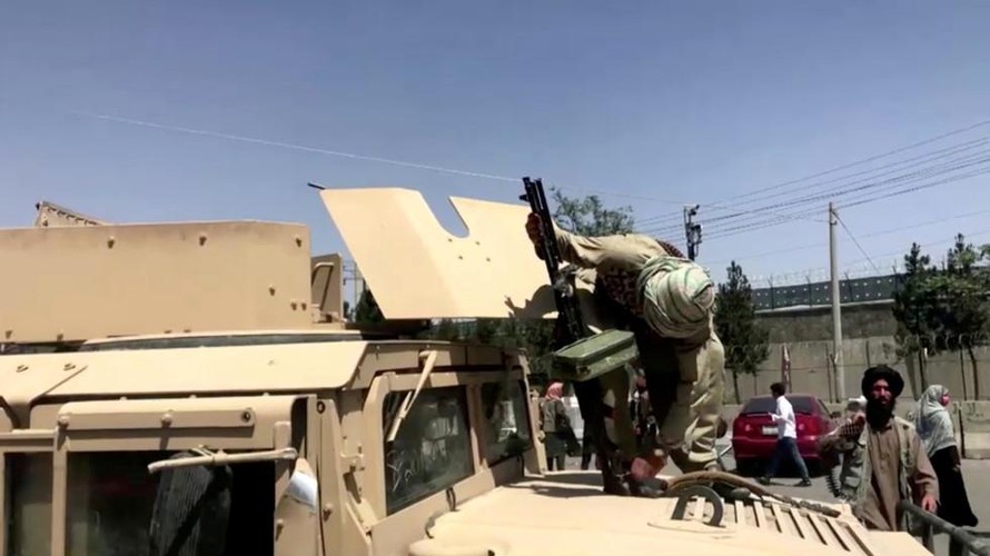 Tay súng Taliban đứng trên nóc xe Humvee của Mỹ ở Kabul. Ảnh: Reuters