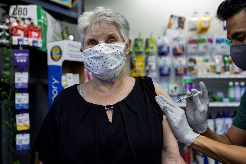Một cụ bà tiêm vắc-xin mũi tăng cường tại một hiệu thuốc ở Mỹ. Ảnh: Reuters