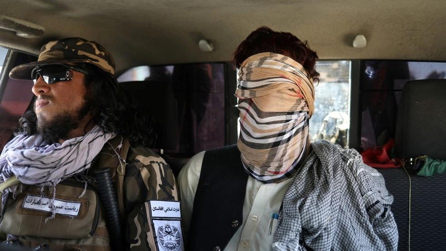 Một tay súng IS (che mặt) bị lực lượng Afghanistan bắt giữ. Ảnh: Reuters