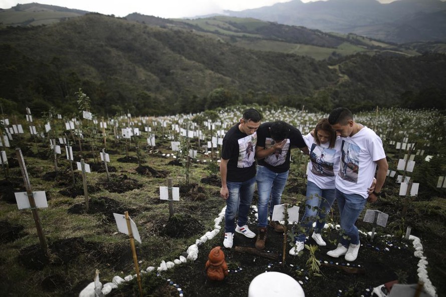 Thân nhân viếng mộ một nạn nhân COVID-19 ở Bogota (Colombia). Ảnh: AP