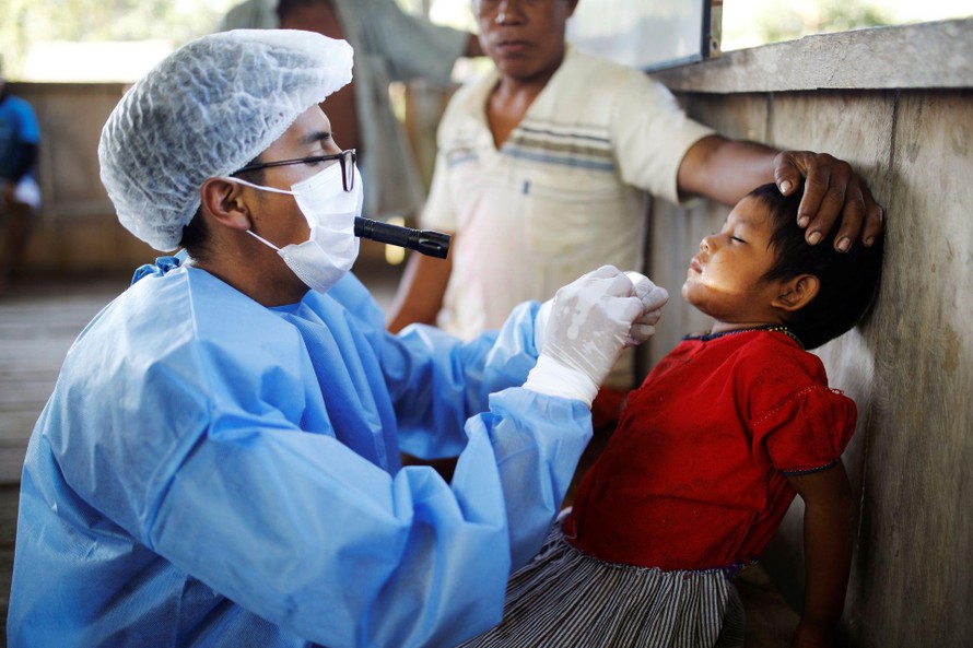 Bác sĩ Neuson Juran Apaza khám bệnh cho một em nhỏ khi đến thăm làng Mangual. Ảnh: Reuters