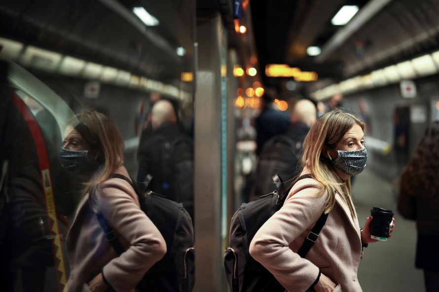 Một phụ nữ đeo khẩu trang khi đi tàu điện ngầm ở London. Ảnh: Reuters