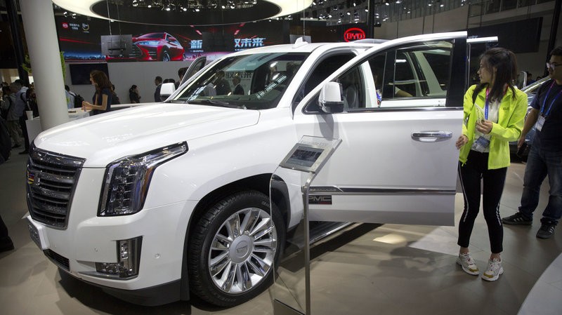 Khách dự triển lãm ô tô Trung Quốc ở Bắc Kinh năm 2018 ngắm xe Mỹ Cadillac Escalade. Đối với hãng General Motors, Trung Quốc là thị trường lớn hơn Mỹ. Ảnh: AP.