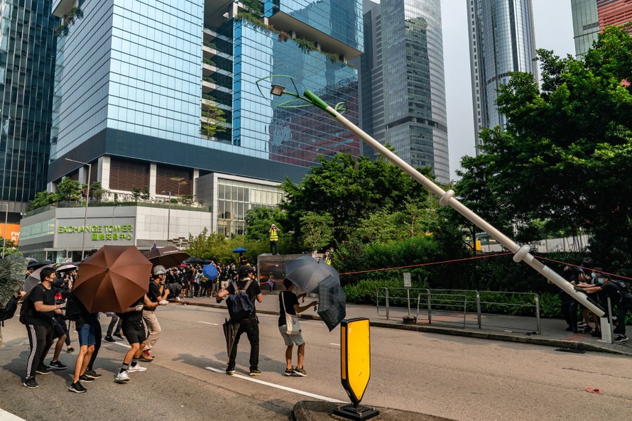 Người biểu tình kéo đổ cột đèn thông minh hồi tháng 8. Ảnh: Getty Images.