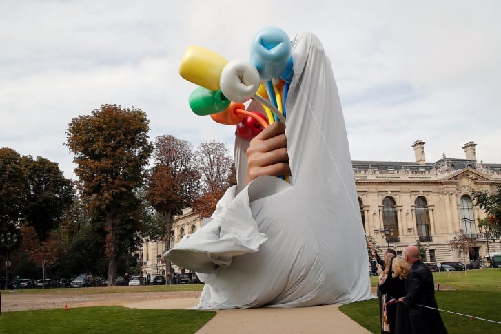 Nghệ sĩ Mỹ Jeff Koons và lãnh đạo thành phố Paris kéo màn khai trương tác phẩm “Bó hoa tulip”. Ảnh: AP.