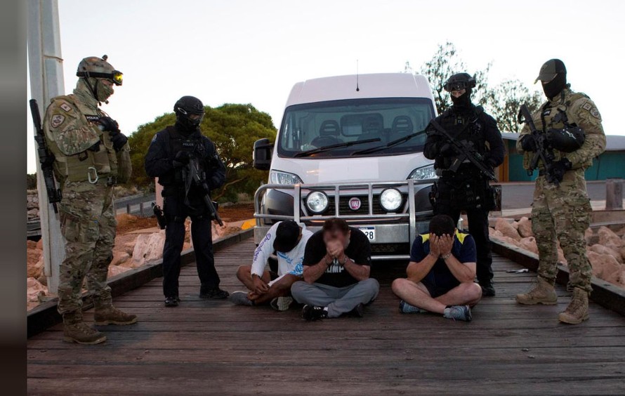 Cảnh sát đứng cạnh các nghi phạm bị bắt trong một chiến dịch triệt phá các băng đảng ma túy, thu được 1,2 tấn methamphetamine ở Úc. Ảnh chụp ngày 21/12/2017. Nguồn: Reuters