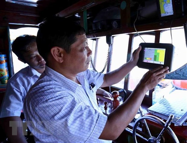 Cán bộ ngành thủy sản kiểm tra thiết bị giám sát hành trình khai thác trên tàu cá trước khi ra khơi, tại cảng cá Quy Nhơn, thành phố Quy Nhơn, tỉnh Bình Định. Ảnh: TTXVN