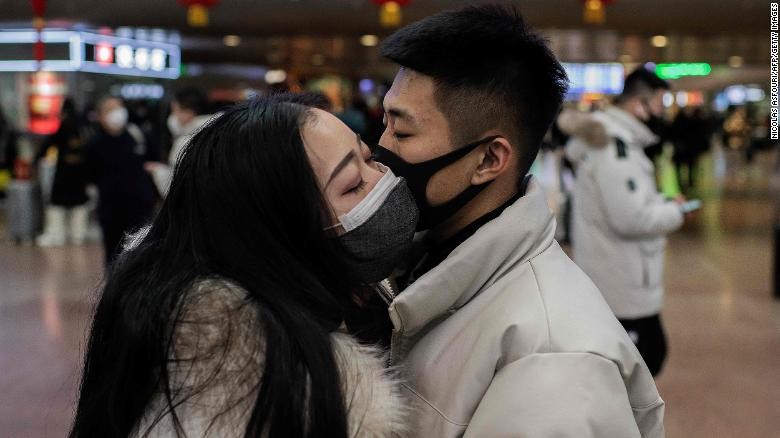 Một đôi uyên ương đeo khẩu trang hôn tạm biệt tại một nhà ga tàu hỏa ở Bắc Kinh. Ảnh: Getty.
