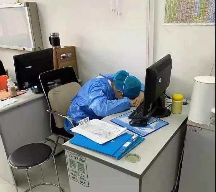 Bác sĩ chống dịch coronavirus mới ngủ gục tại bàn làm việc vì làm việc không nghỉ trong hàng chục giờ. Họ mặc nguyên đồ bảo hộ, đeo bỉm, thậm chí có người cạo trọc đầu... để tiết kiệm thời gian mặc đồ. Ảnh: CCTV News.