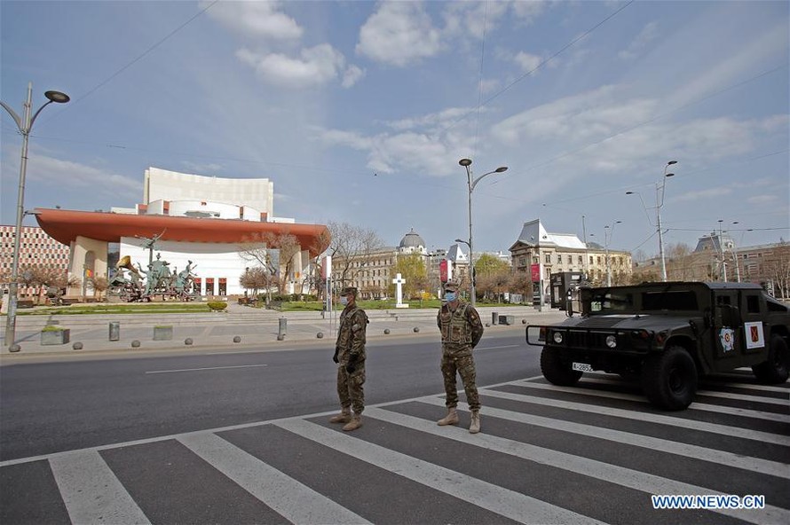 Binh sĩ đeo khẩu trang đứng gác trên đường phố thủ đô Bucharest của Romania ngày 28/3. Ảnh: Xinhua.