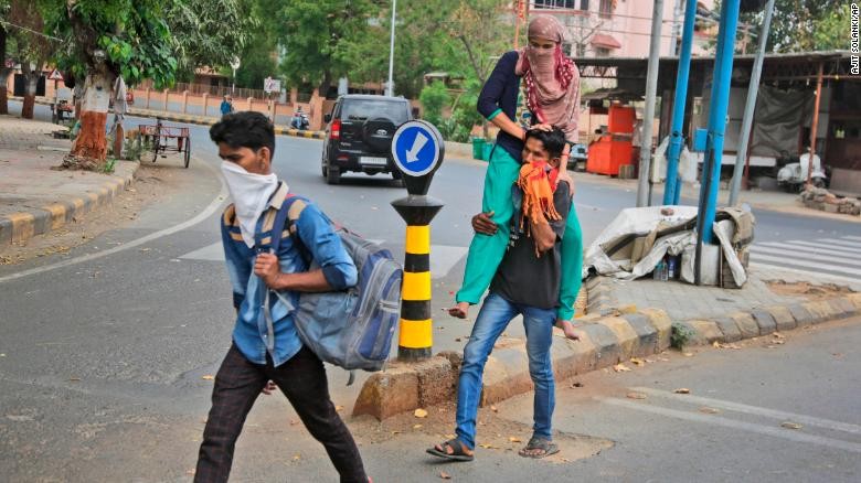 Lao động nhập cư về quê nhà sau khi Ahmedabad, thành phố lớn nhất ở bang Gujarat của Ấn Độ, bị phong tỏa. Ảnh: AP 