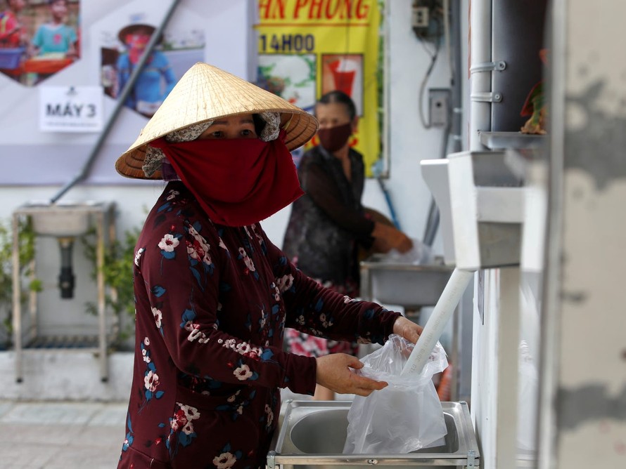 Nhận gạo miễn phí ở ATM gạo tại TPHCM. Ảnh: Reuters.