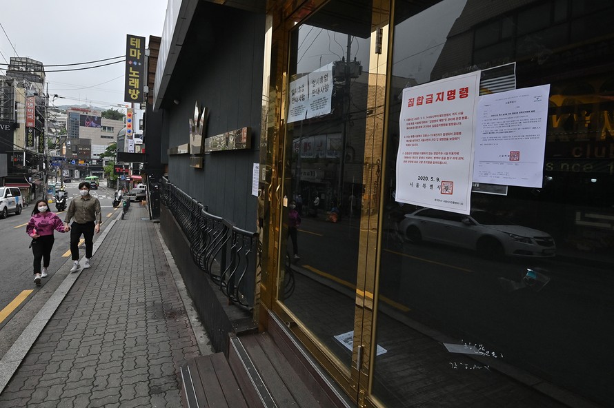 Một cặp đôi đeo khẩu trang bước ngang một hộp đêm đóng cửa ở Itaewon hôm 10/5. Ảnh: Getty Images.