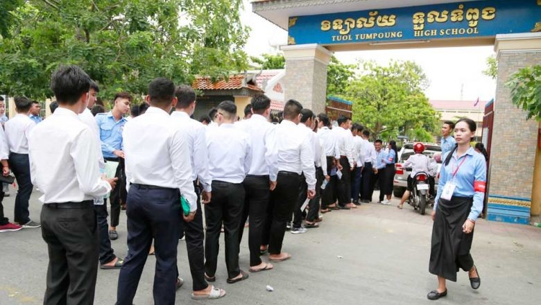Học sinh lớp 12 xếp hàng vào một trường THPT ở thủ đô Phnom Penh của Campuchia để thi tốt nghiệp năm ngoái. Ảnh: The Phnom Penh Post.